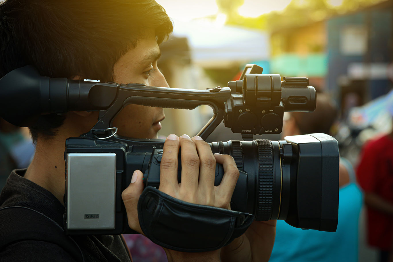 Young man holding a video camera.